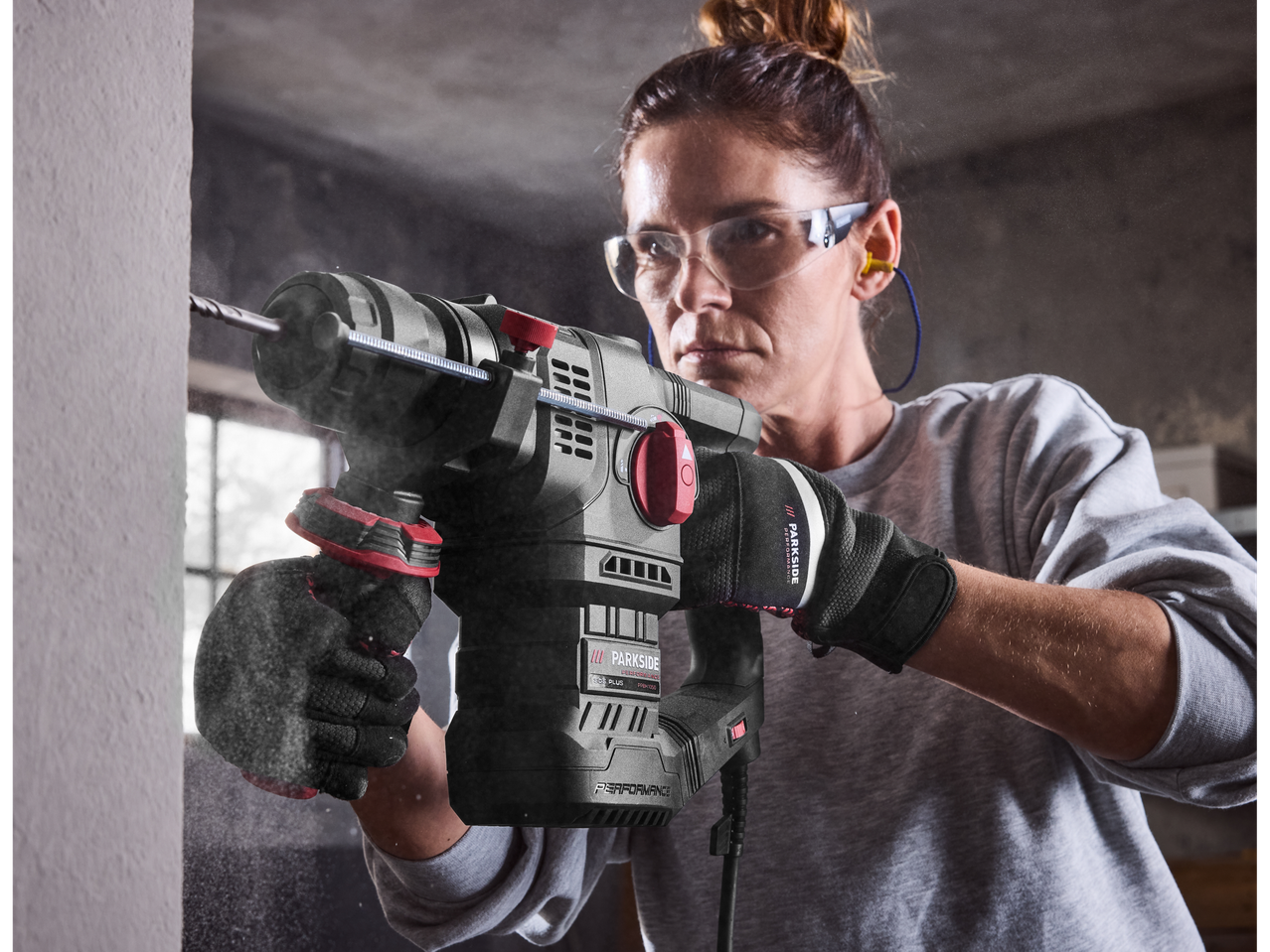 Жена използва перфоратор Parkside Performance® Kombinirani čekić за пробиване на стена.