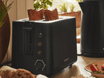 Ein schwarzer Toaster von Urban Outfitters mit zwei gerösteten Brotscheiben.