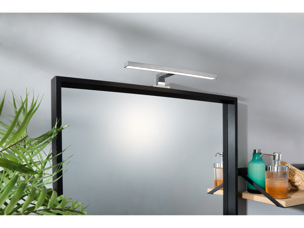 Livarno Home LED lampa iznad ogledala sa kupatilskim proizvodima.