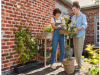 Two women gardening with Parkside® Balcony Box and other gardening tools on a wooden deck.