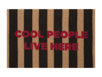 Dørmåtte med sorte og beige striber og teksten 'COOL PEOPLE LIVE HERE' i rød.