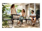 Three friends enjoying drinks on a patio with outdoor furniture, including a bench, chairs, and a table.