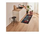 A modern kitchen with a black sink, wooden countertop, and a chili-themed kitchen mat.