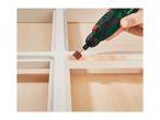 A person using a rotary tool with a sanding attachment on a white wooden frame.