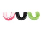 Three colorful mouthguards in pink, black, and green.