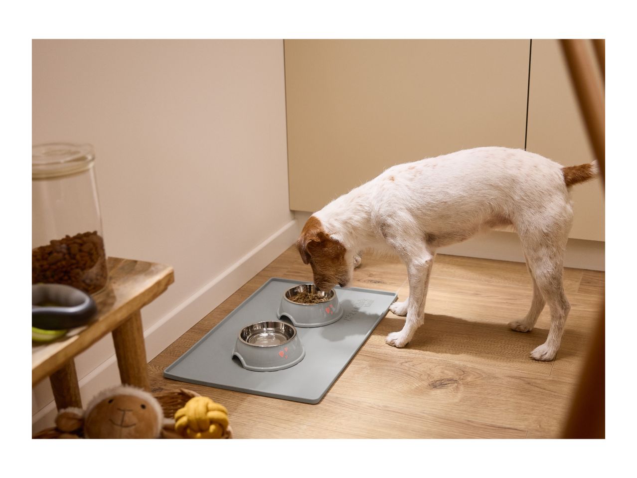 A dog eating from a bowl on a grey silicone feeding mat.