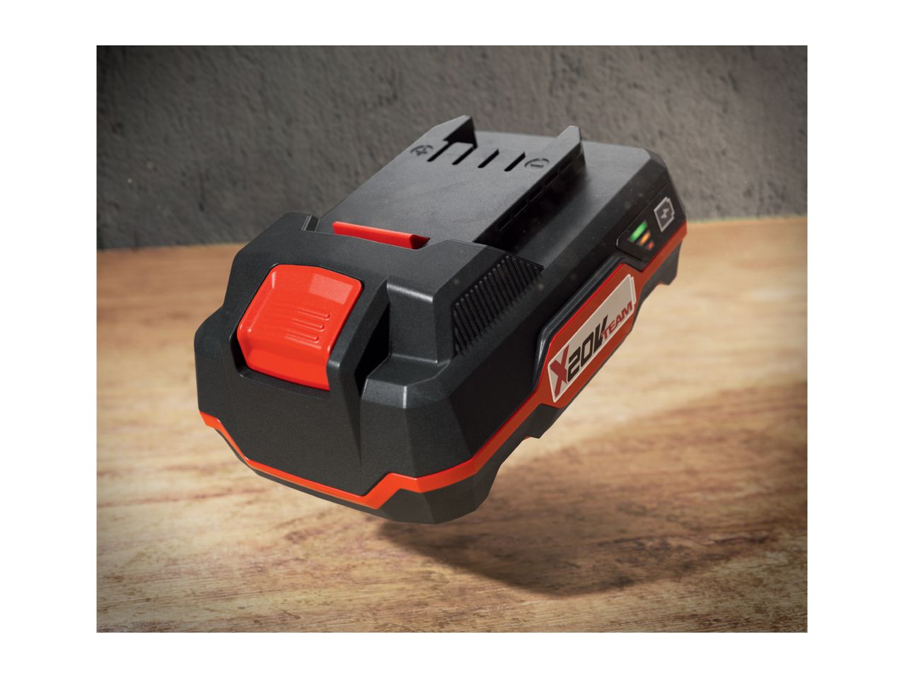 A black and red X 20V Team power tool battery on a wooden surface.