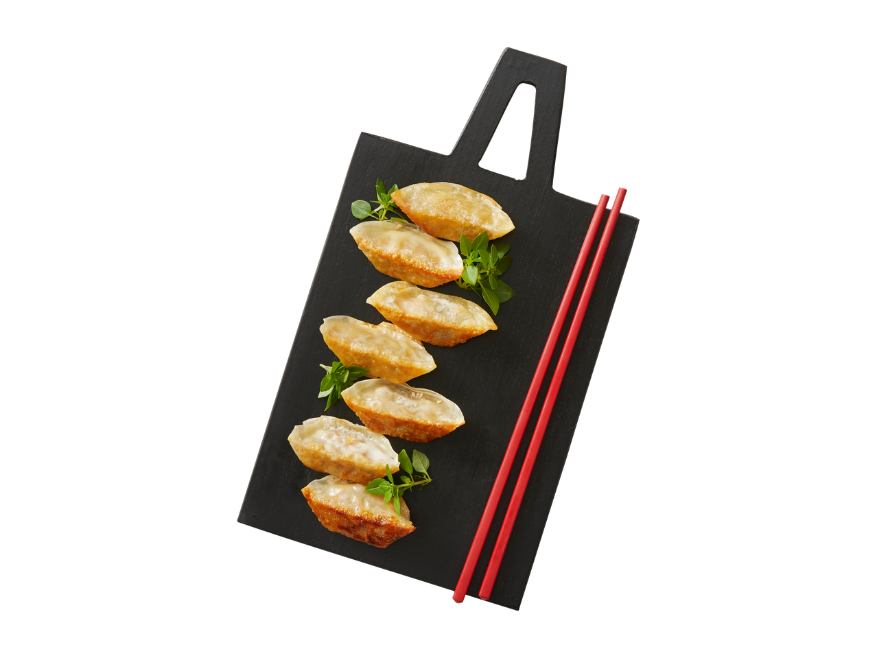 Gyoza frita em uma tábua preta com pauzinhos vermelhos.