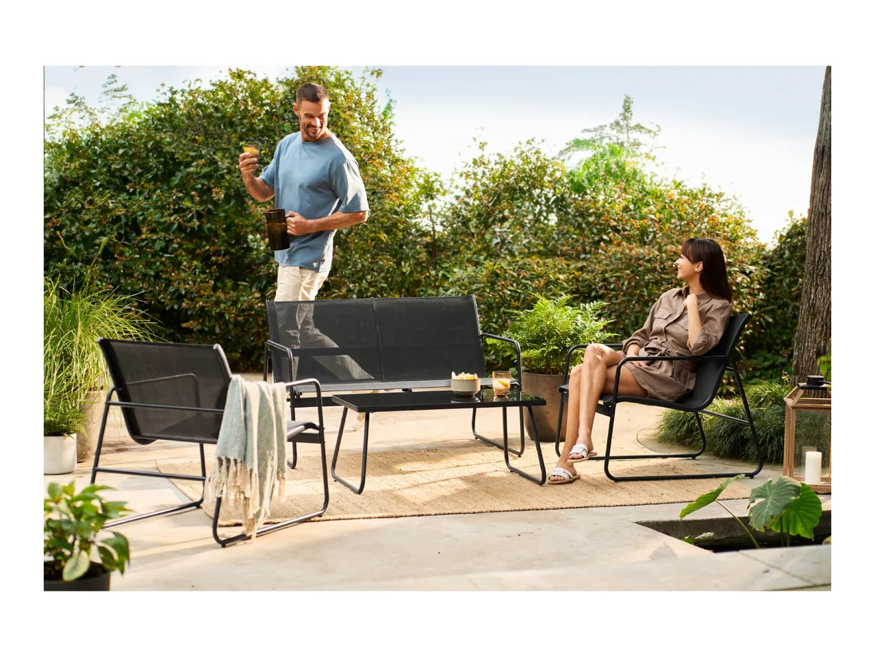 Outdoor lounge set with two chairs, a two-seater sofa, and a coffee table on a patio.