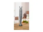 A SilverCrest hand blender on a wooden surface with pesto ingredients.