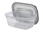 A clear plastic food storage container with a dark gray lid leaning behind it.