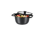 Oală neagră de bucătărie cu legume și capac de sticlă.