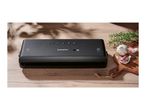 SilverCrest vacuum sealer on a wooden table with garlic and rosemary.