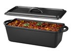 Cast iron loaf pan with lid, filled with chili con carne and garnished with basil.