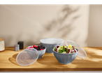 Silvercrest bowls with lids, one filled with berries, another with salad, on a wooden counter.