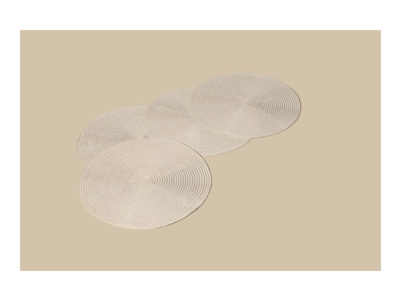 Four round, light beige woven placemats arranged diagonally on a beige background.