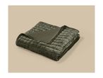 A folded olive green quilted velvet blanket on a beige background