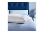 A white Silentnight pillow on a bed with blue bedding and a blue headboard.