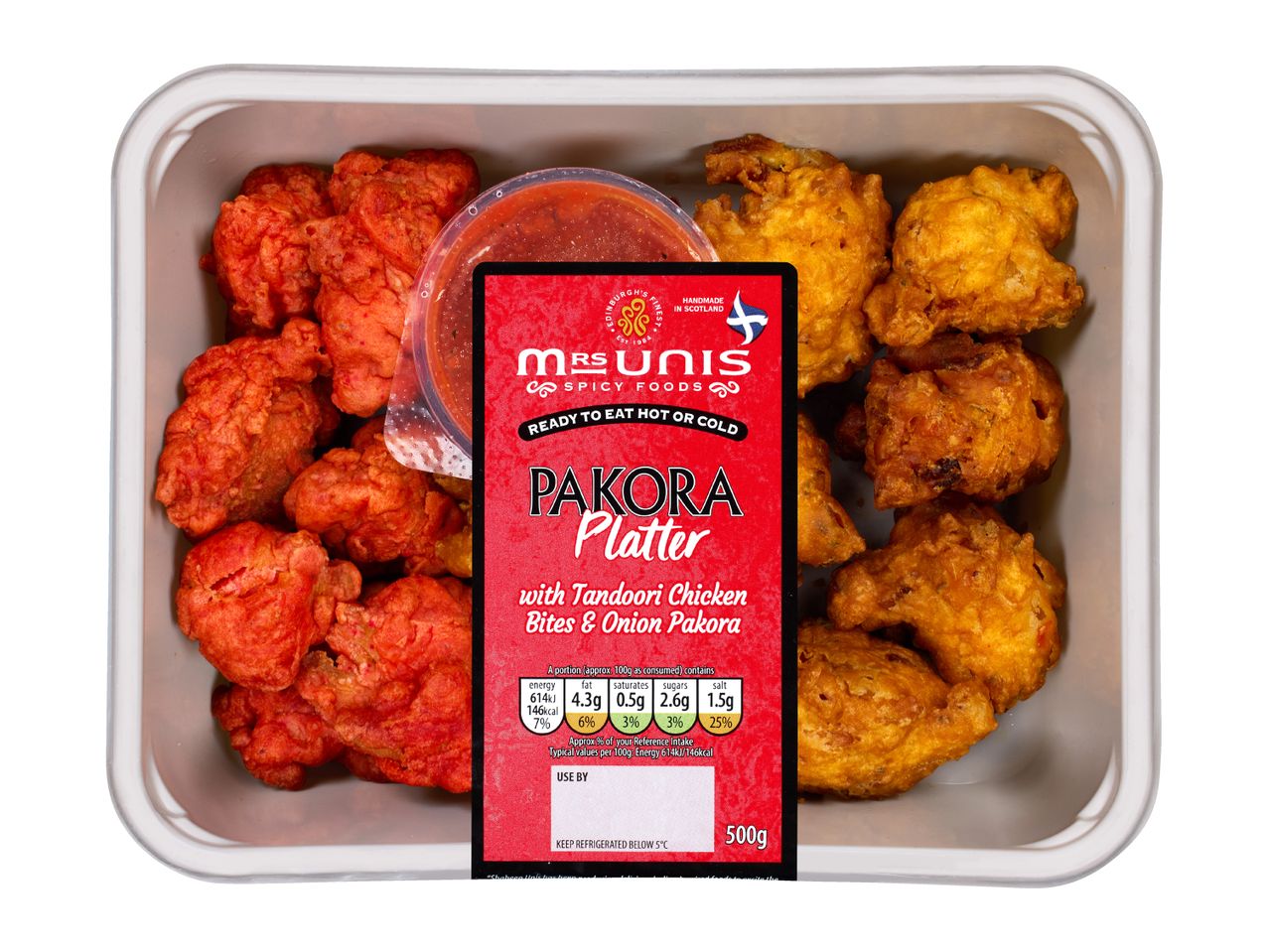 Pakora platter with tandoori chicken bites and onion pakora, with a red sauce.