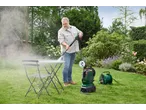 Homem a limpar uma mesa de jardim com uma máquina de lavar à pressão PARKSIDE.