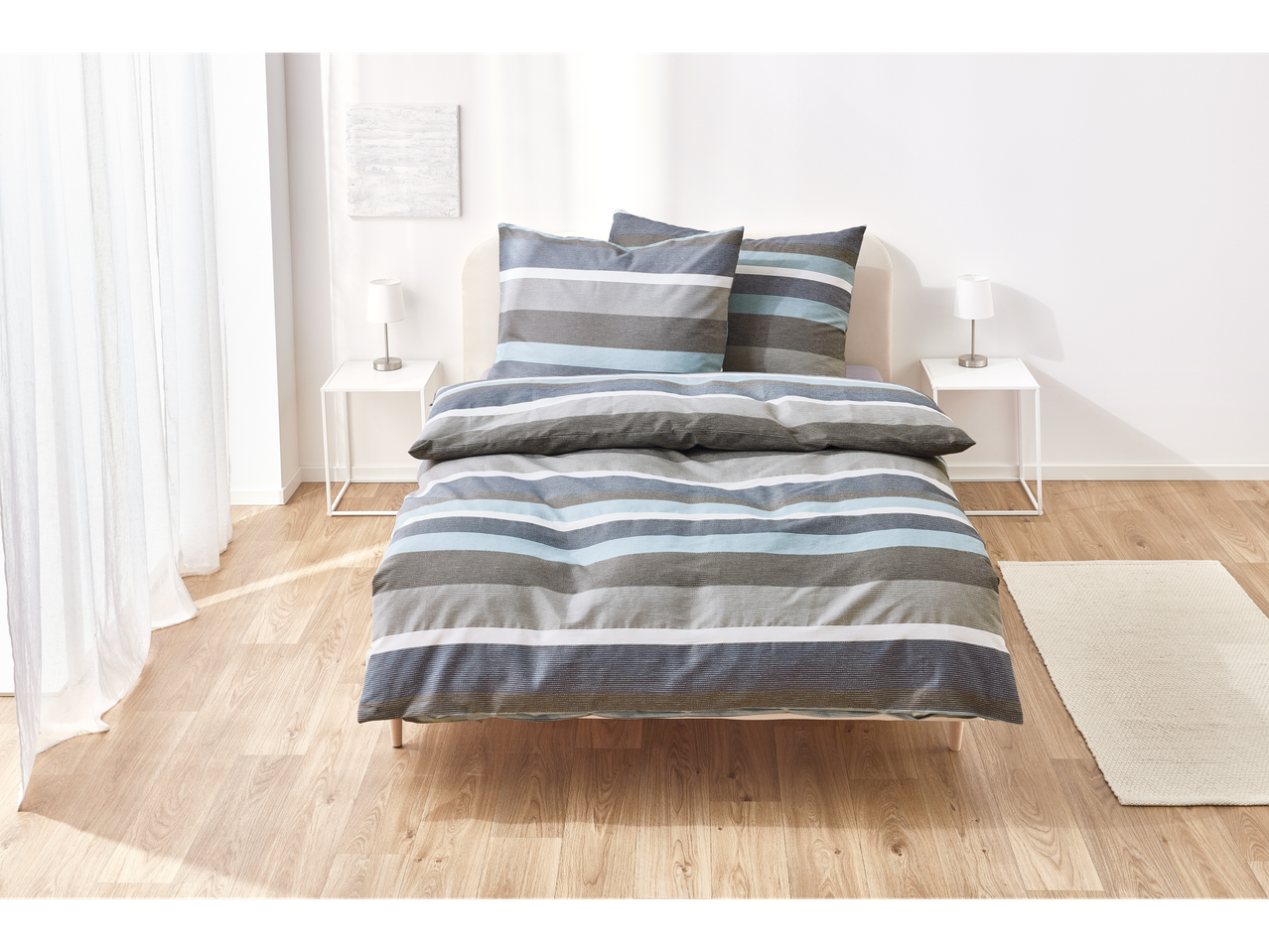 Grey and blue striped bedding on a bed.