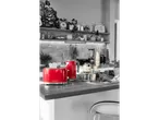 Red toaster and kettle on a kitchen counter with other appliances and decor.