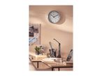 Wall clock with thermometer and hygrometer above a desk with office supplies.