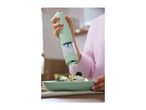 A person using an electric salt or pepper grinder to season a fresh salad.