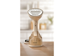 Escova a vapor Silvercrest® numa mesa de madeira, com cozinha desfocada ao fundo.