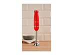 Red hand blender with '1973' text on a wooden countertop in front of a tiled wall