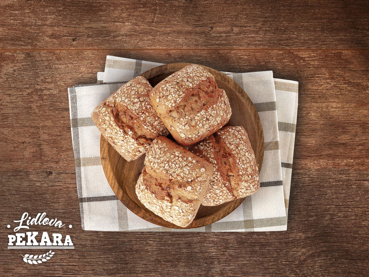 Lidl-ova Pekara: četiri hrskava peciva s ražom na drvenom tanjuru.