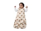 Baby in a beige sleep sack with bear, moon, and star patterns, holding a wooden block.
