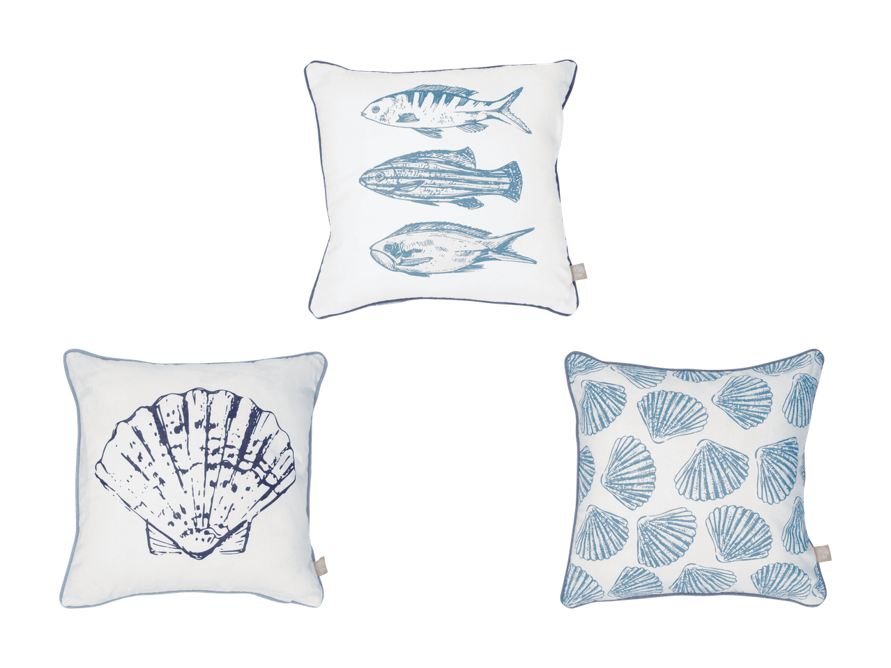 Drei weiße Kissen mit blauen Meeresmotiven: Fische, eine große Muschel und ein Muschelmuster.