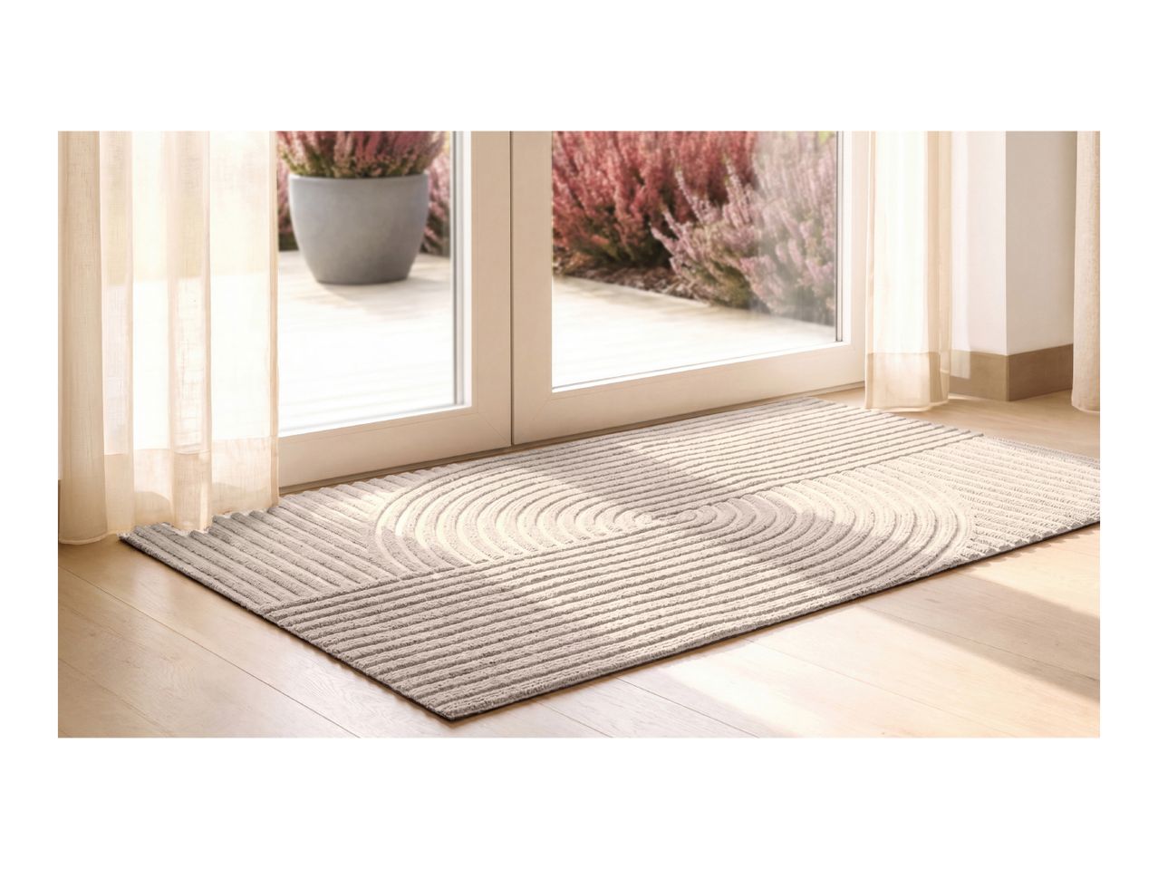 Textured beige doormat with a zen-like raked pattern in front of a glass patio door.