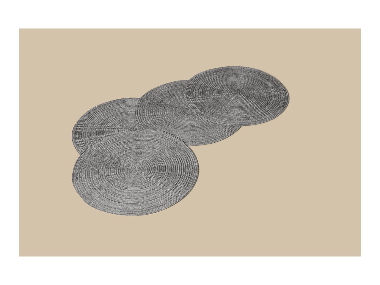 Four round, grey woven placemats arranged diagonally on a beige background.