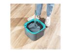 Person cleaning a wooden floor with a spin mop and bucket.