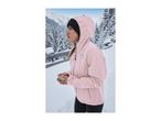 A woman in a pink hooded outdoor jacket stands in a snowy winter landscape.