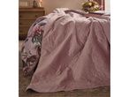 Pink quilted bedspread with floral duvet cover in a cozy bedroom setting