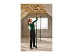 Woman installing ceiling support props in an attic with exposed wooden beams.