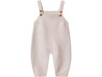 Knitted baby romper in a light beige color with wooden buttons on the straps