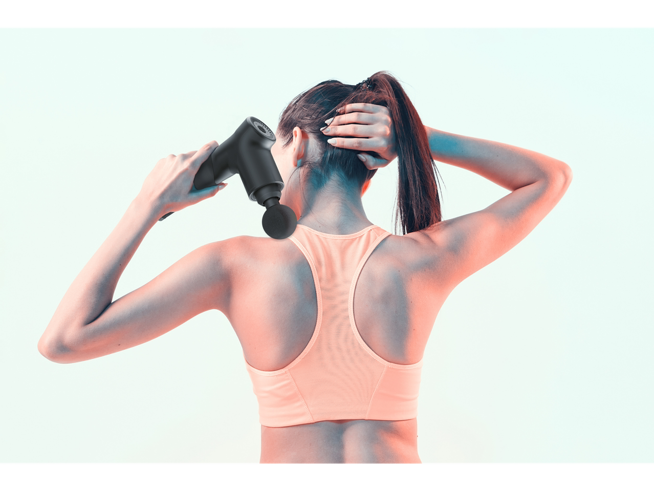 Woman using a massage gun on her neck and back.