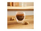 Espresso in a double-walled glass with amaretti biscuits on a wooden table.