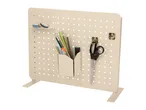 Beige pegboard with a shelf holding washi tape, a pen holder with pencils, and scissors hanging from hooks.