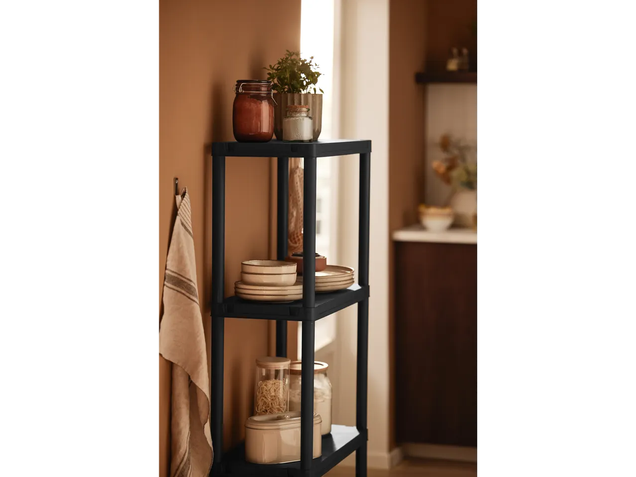 Rafturi din plastic negru cu borcane de sticlă și vase.