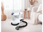 Aspirador de estofos SILVERCREST® numa sala de estar clara com decoração neutra.