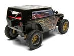 Black toy off-road vehicle with flame decals and gold wheels, viewed from the rear at an angle.