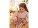 A girl doing diamond painting on a wooden table.