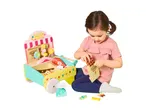 A child playing with a wooden candy shop toy, putting a chocolate bar into a paper bag.