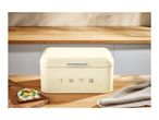 Retro-style cream bread bin with the year 1973 on a wooden countertop