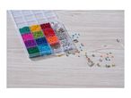Bead organizer with colorful beads, charms, and a partially strung necklace on a wooden surface.